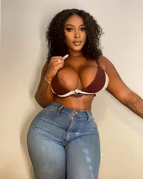 Sexy black girl poses in push-up bra and jeans to show off curvy figure.